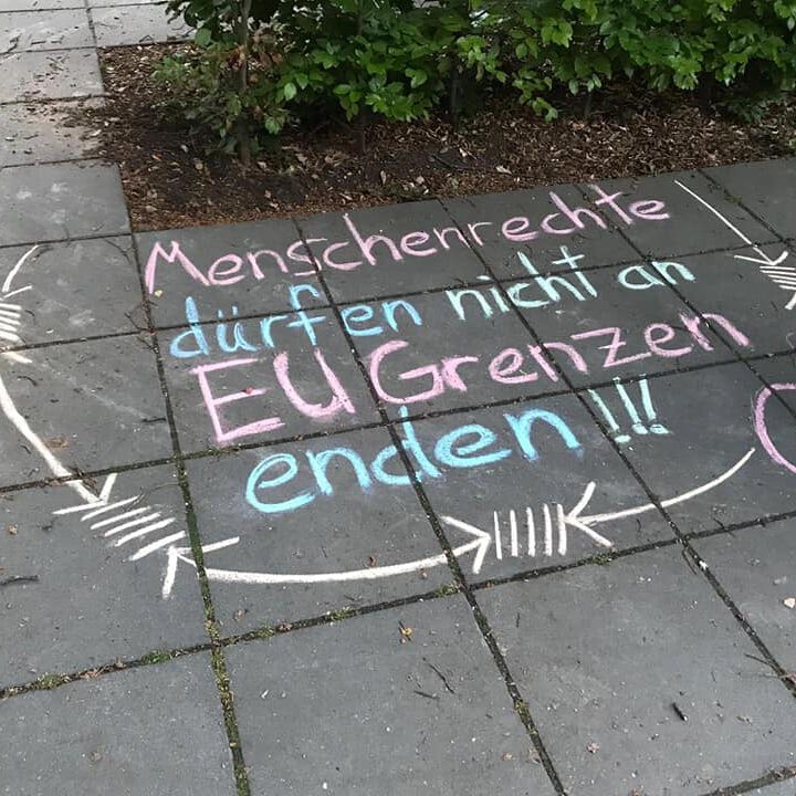 "Menschenrechte dürfen nicht an EU-Grenzen enden" mit Kreide auf das Trottoir geschrieben.